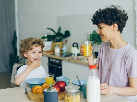 Ibu dan anak menikmati sarapan bersama di rumah